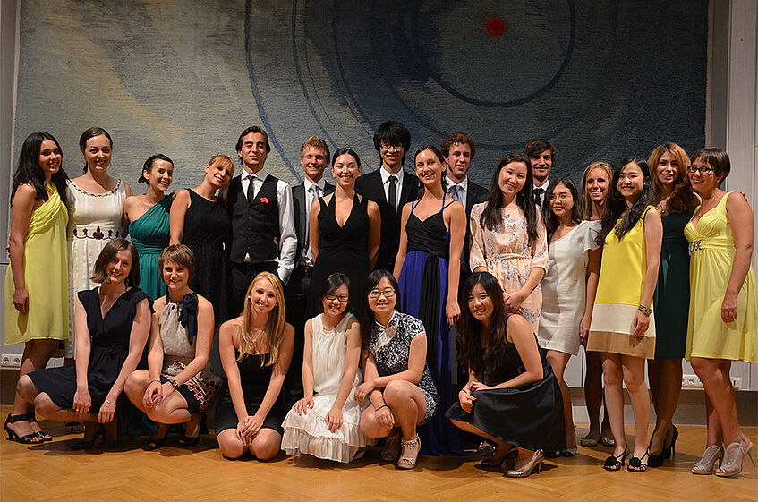 A group of students dressed up in cocktail dresses and suits.