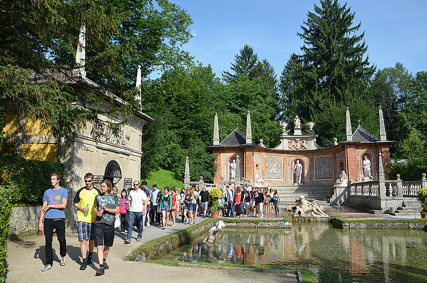 Students taking a guided tour of the trick fountains in Schloss Hellbrunn.
