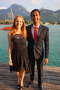Couple in elegant clothes on wooden pier with lake in the background