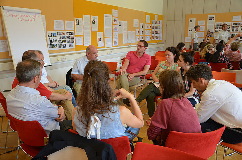 Sesselkreis mit Teilnehmern des Sommerdiskurses während eines Workshops
