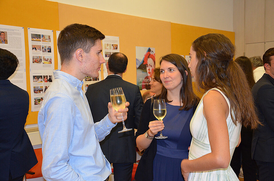 Guests at the cocktail reception in front of the anniversary exhibition