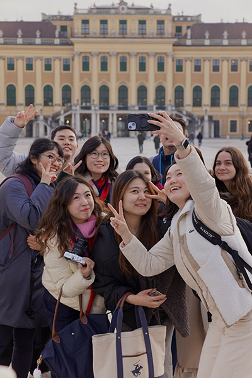 A group of international students making a selfie in front of Schönbrunn Palace