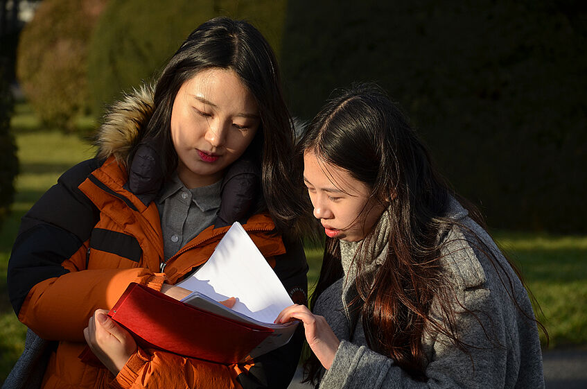 Two girls looking at a sheet of paper