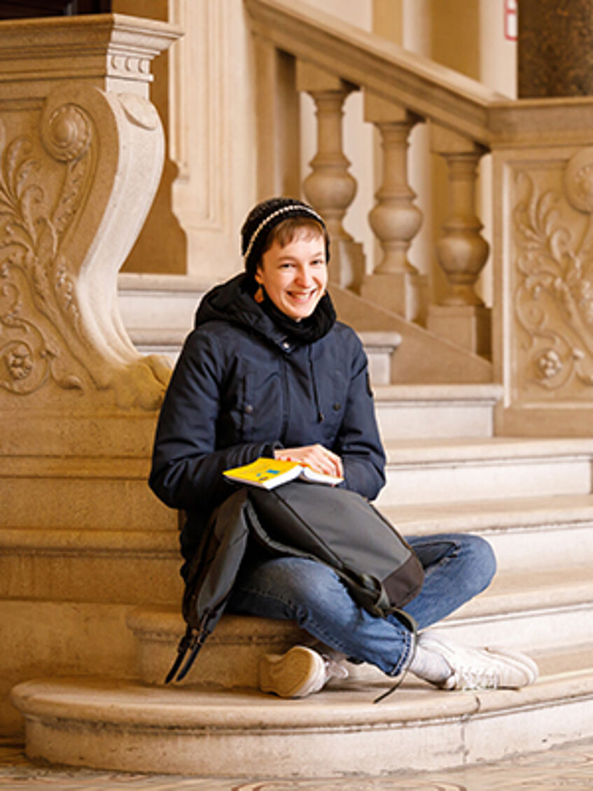 Student on stairs in the Arkadenhof of the University of Vienna