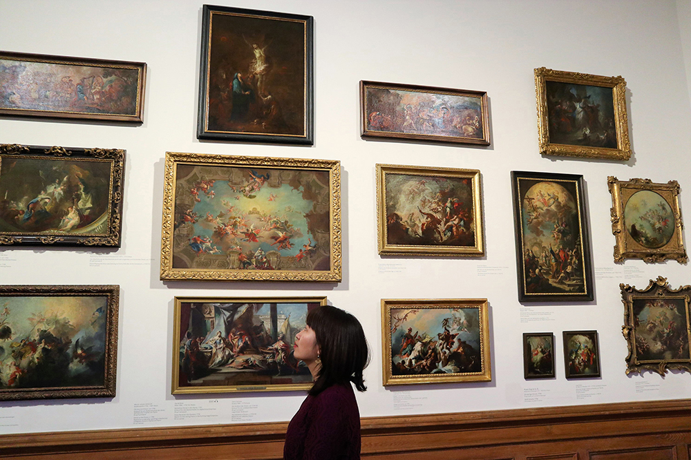 Girl in front of paintings in a museum